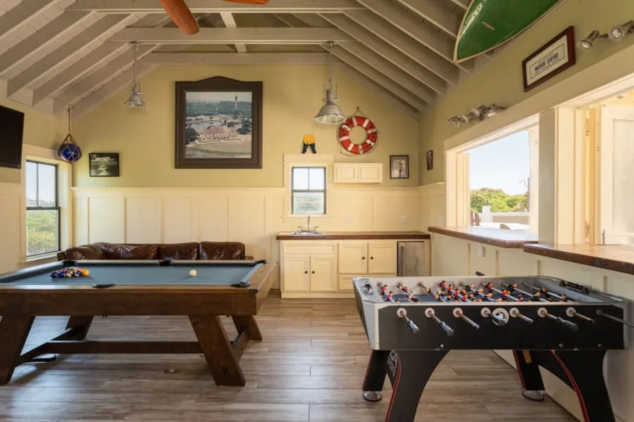 Sala de juegos con mesa de billar y futbolín.