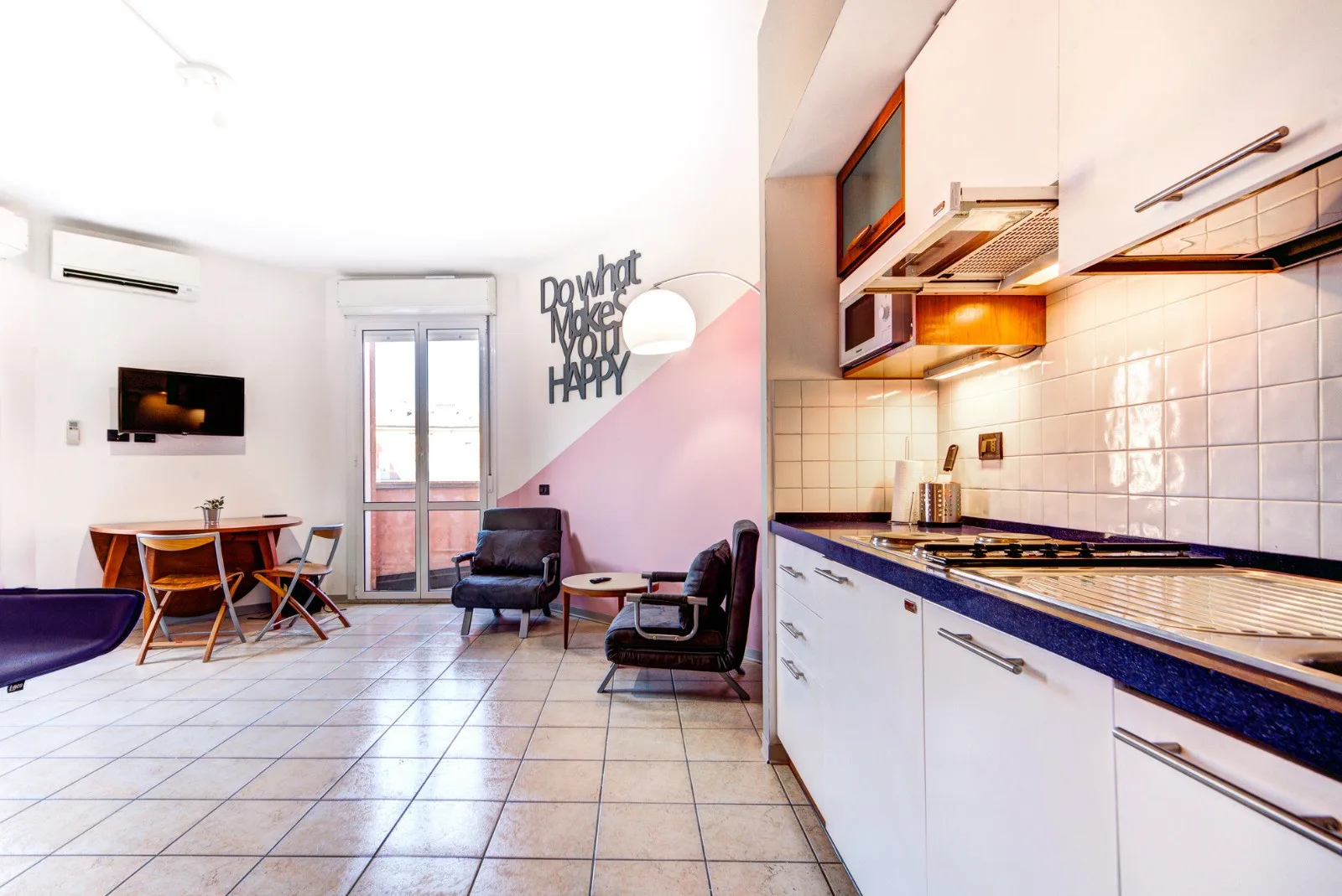Una luminosa sala de estar de planta abierta y cocina, con mesa de comedor y asientos.