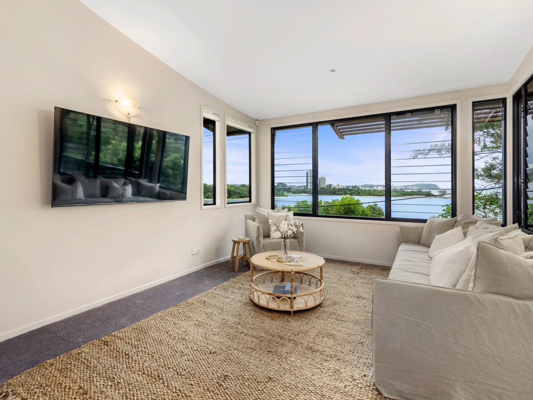 A bright living room with seating arranged beside large windows.