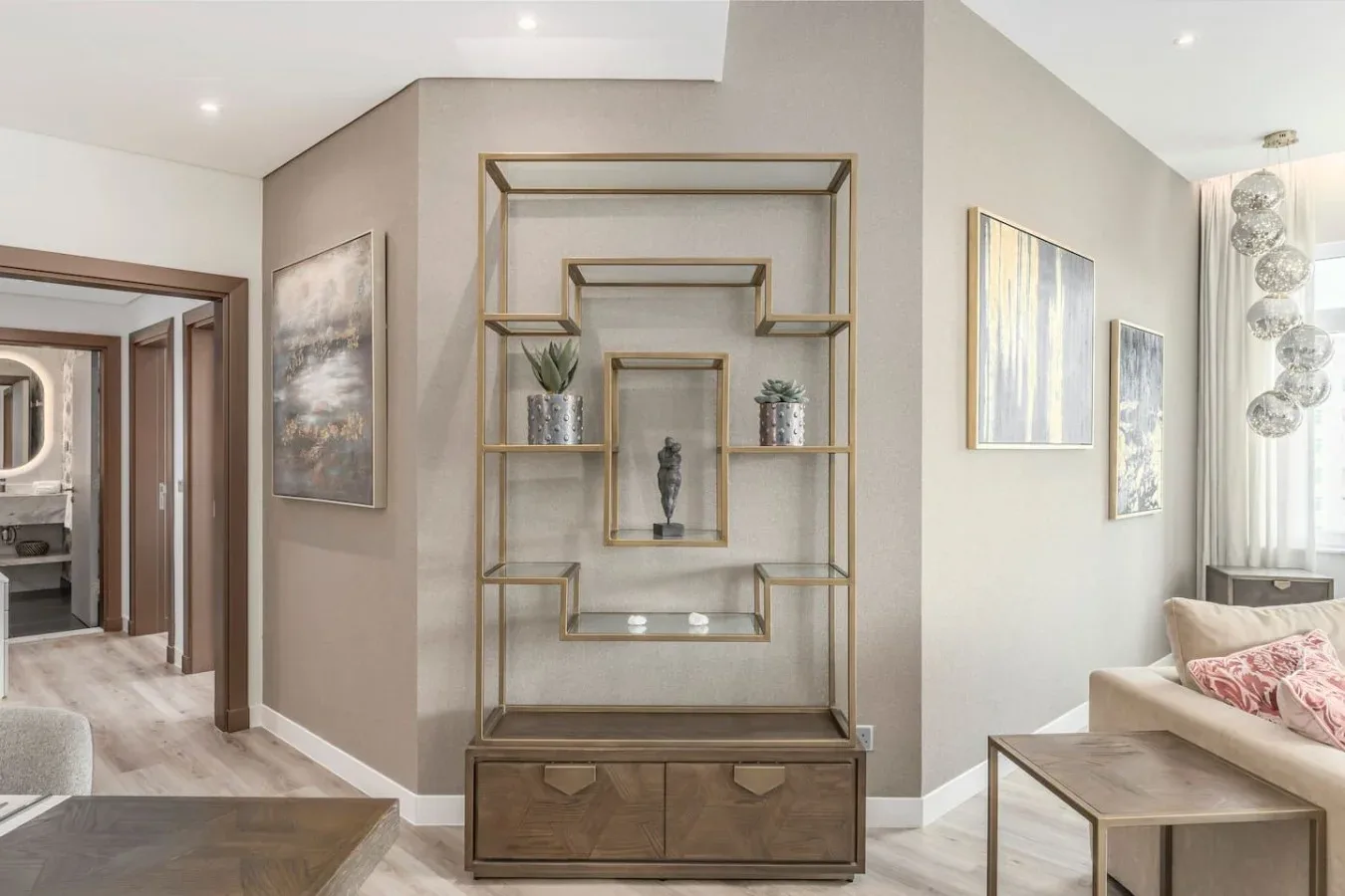 A living room with a shelving unit, decorative objects, and seating.