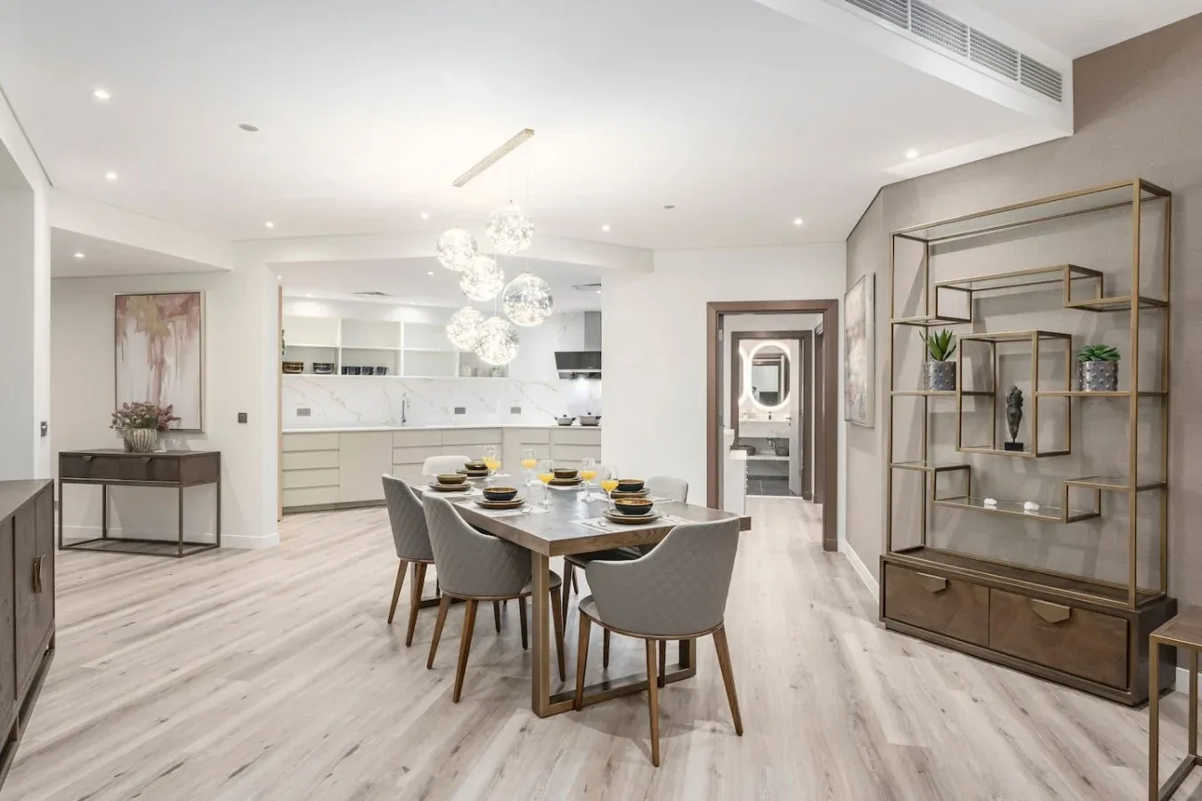 A bright dining area with a table and seating beside an open kitchen.