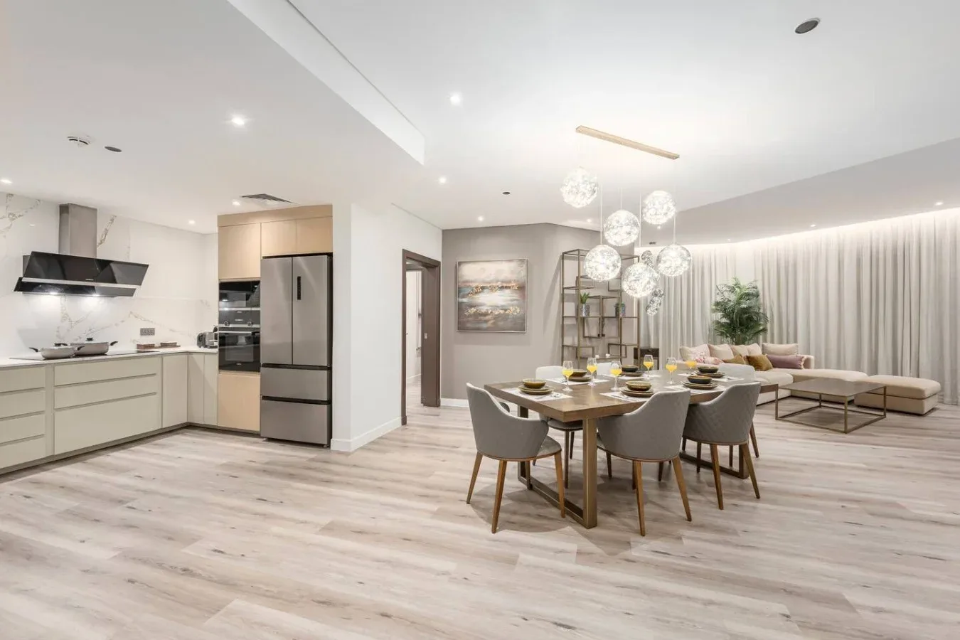 Open-plan dining and living area with a dining table beside the kitchen.
