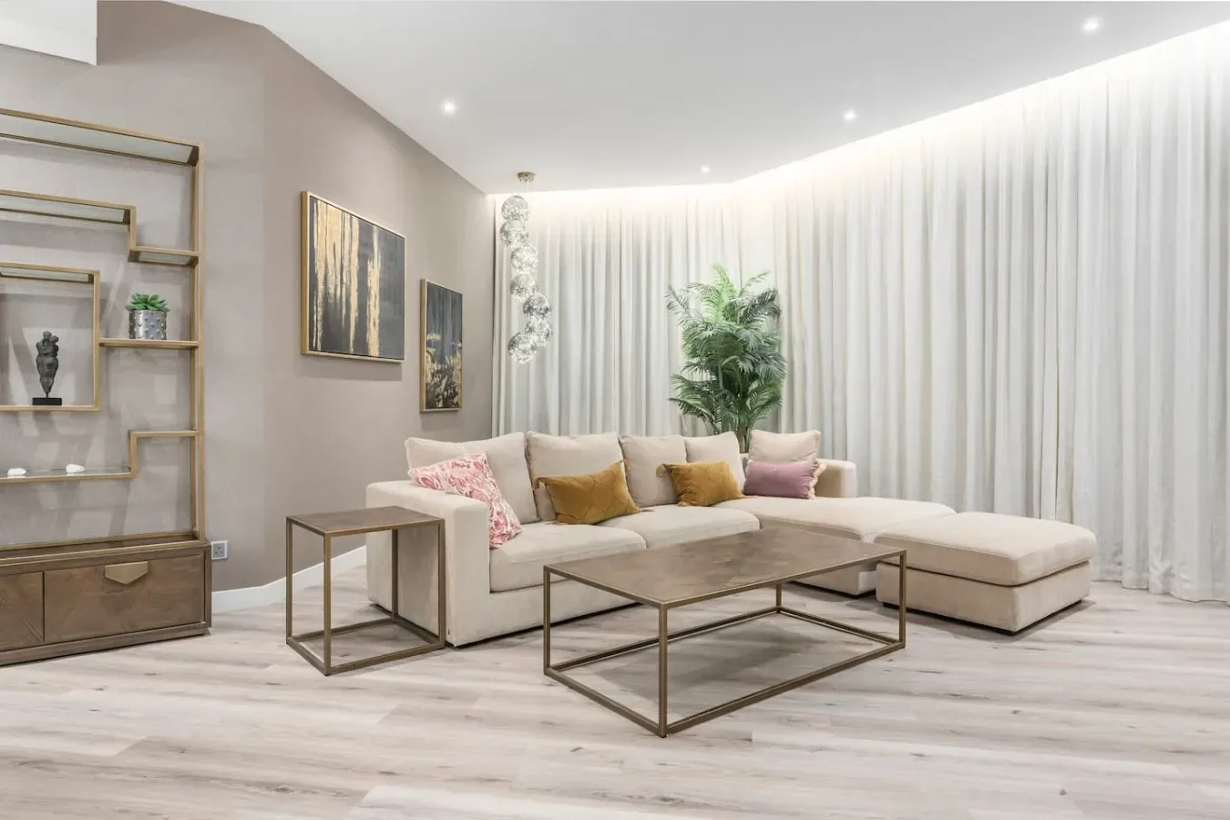 A bright living room with a sectional sofa, coffee table, and floor-to-ceiling curtains.