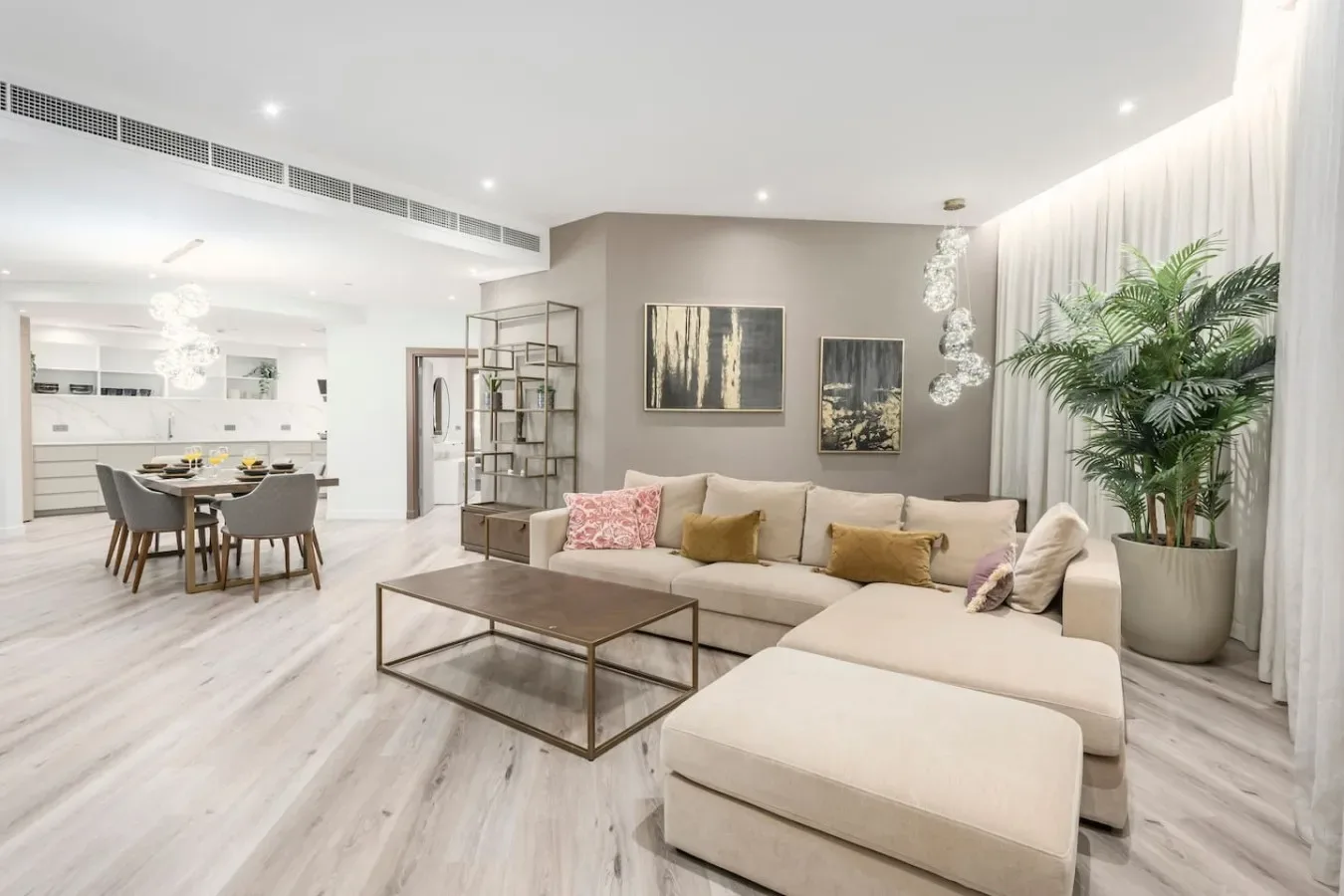 A bright open-plan living and dining area with a sectional sofa and dining table.
