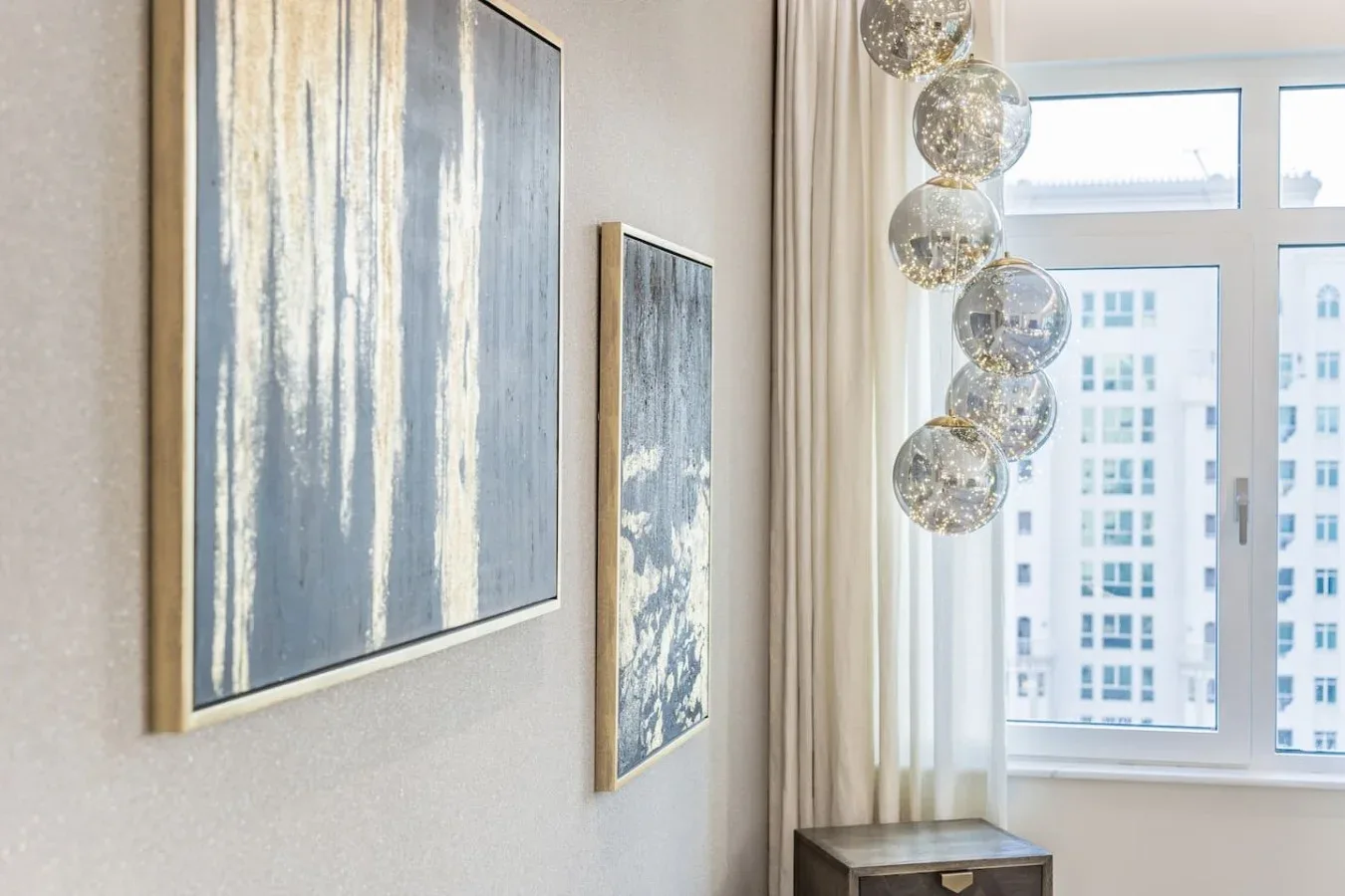 A bright room with framed abstract art and a large window.