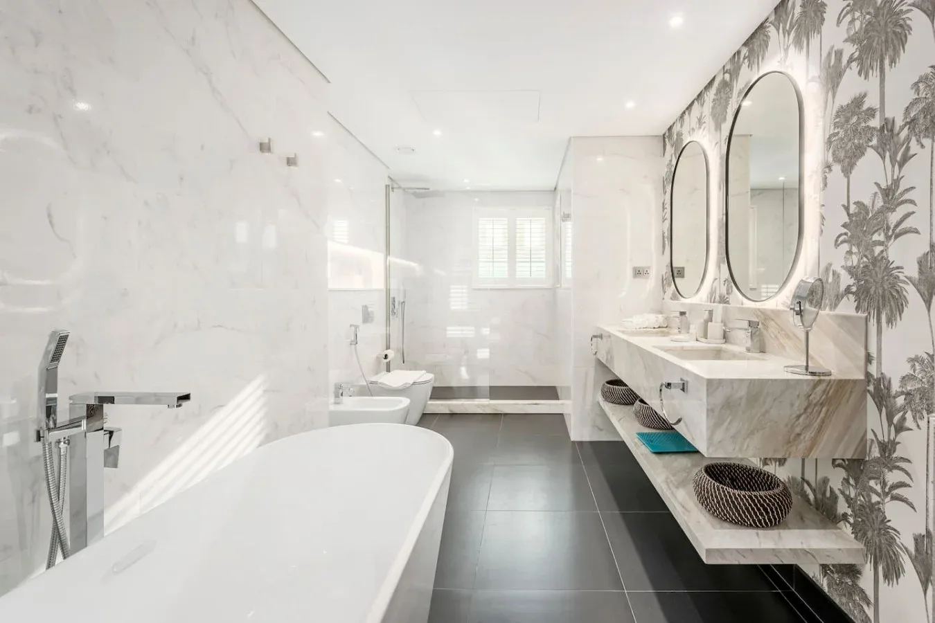 A bright bathroom with a bathtub, walk-in shower, and double vanity.