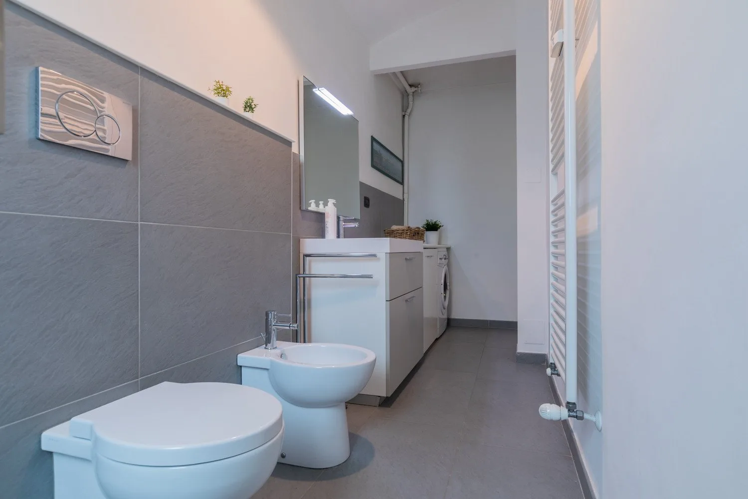 Un baño moderno con lavabo, mueble de baño e inodoro.