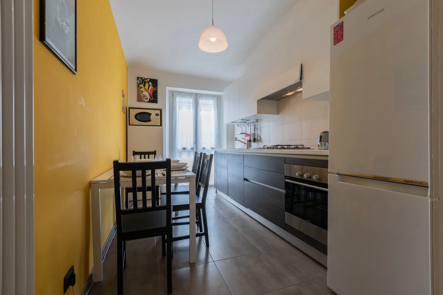 Una cocina estrecha con zona de comedor y una mesa junto a la encimera.