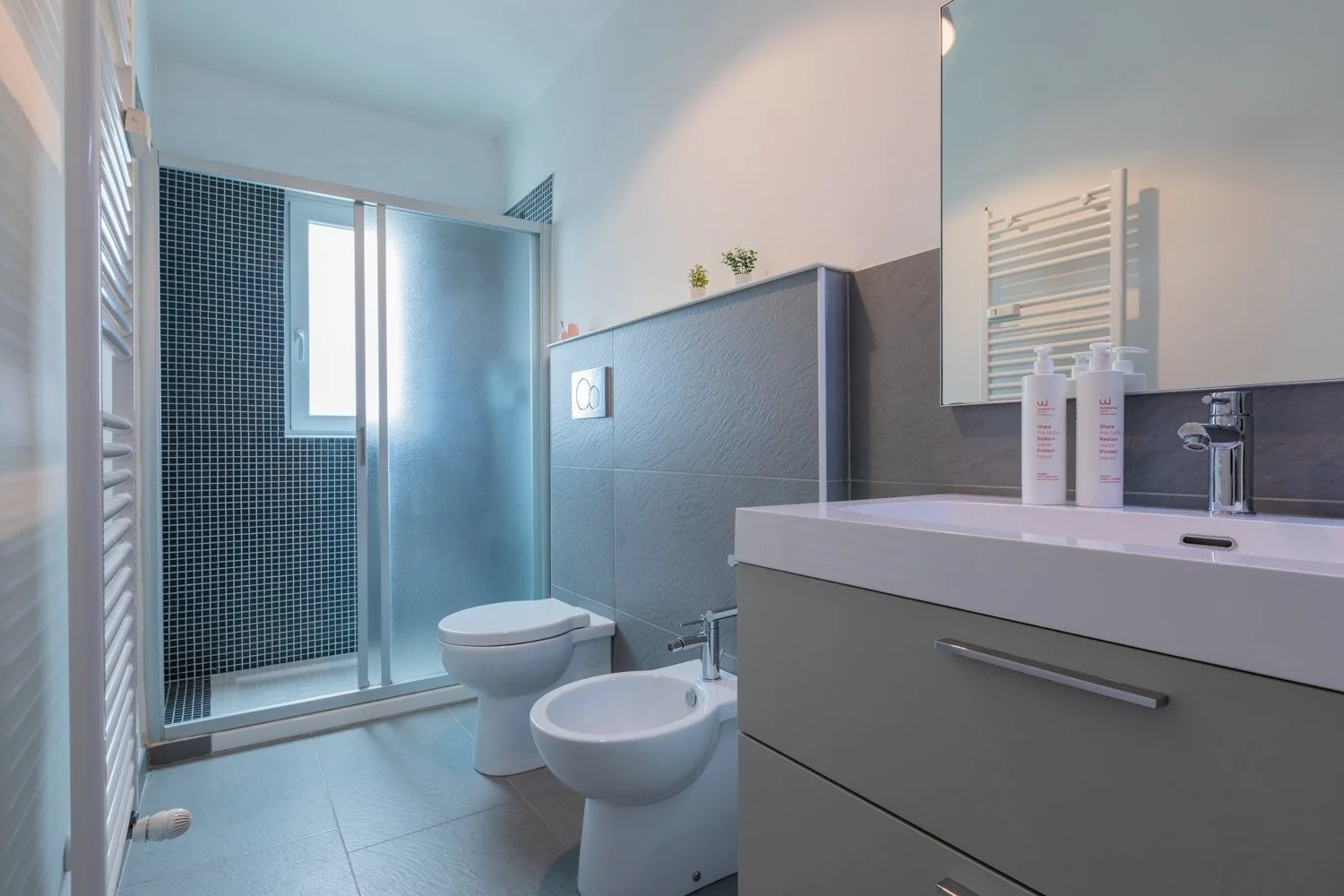 Un baño moderno con ducha de vidrio, inodoro y lavabo.