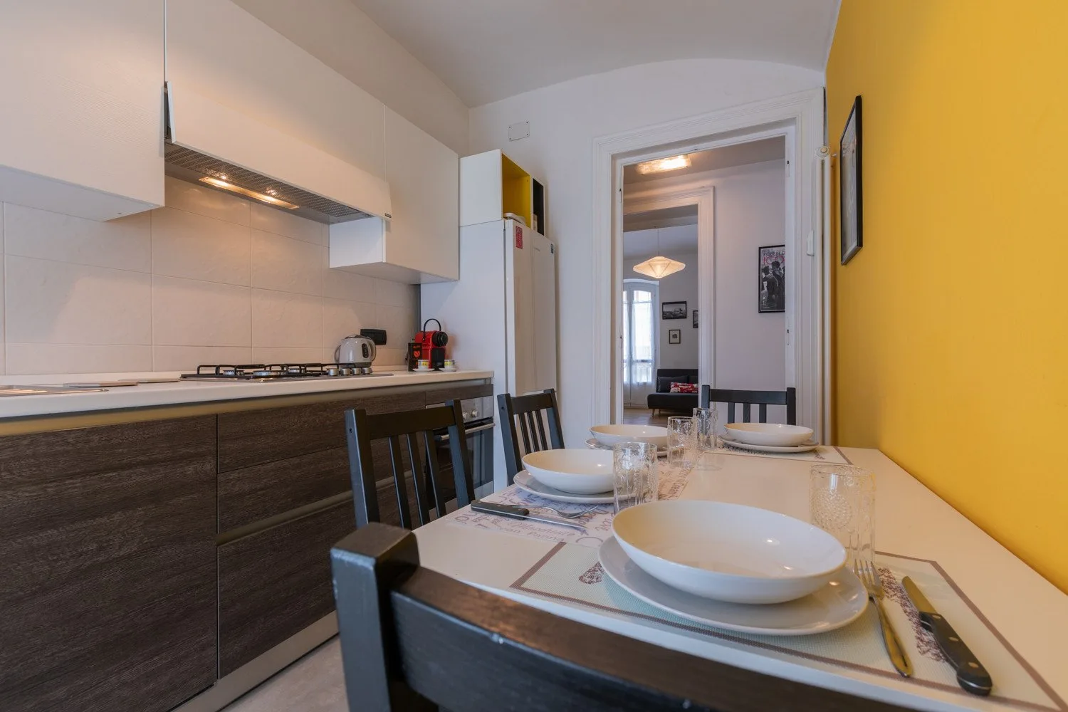 Una mesa puesta está junto a una cocina compacta.