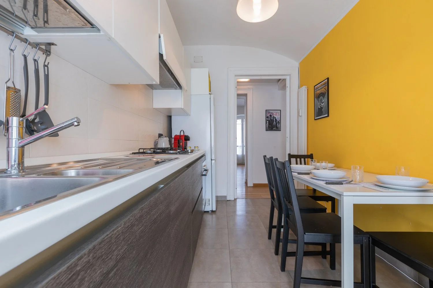 Una cocina estrecha con zona de comedor, encimera y mesa puesta.