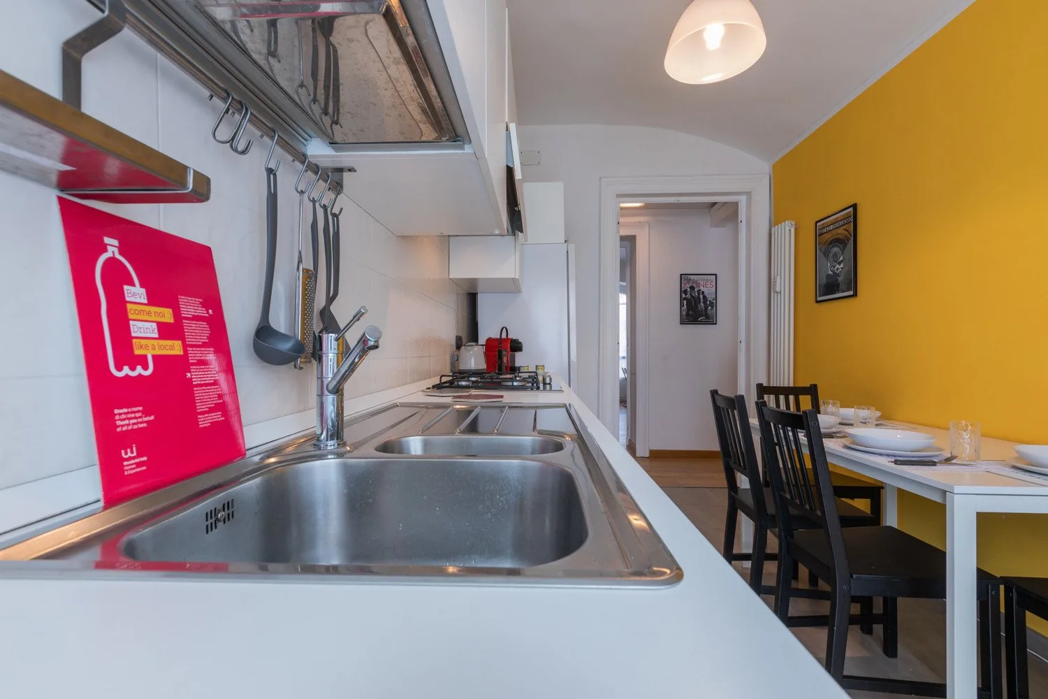 Cocina y comedor con un fregadero de acero inoxidable y una mesa.