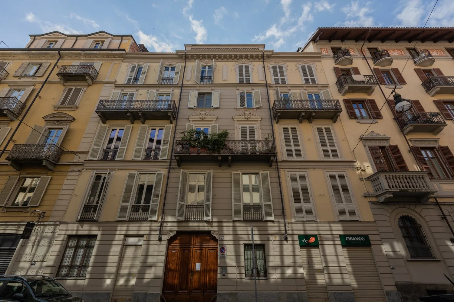 Una hilera de edificios urbanos de apartamentos con ventanas con persianas y balcones.