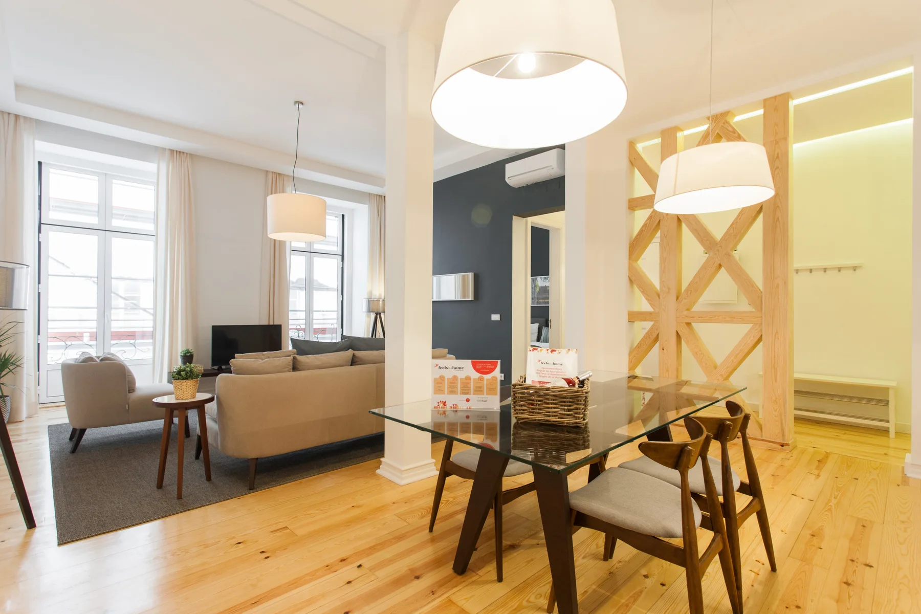 Una luminosa sala de estar y comedor con asientos, una mesa de cristal y ventanas grandes.
