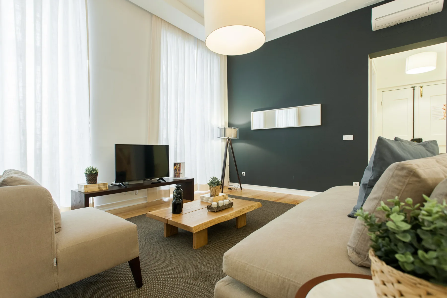 Una sala de estar con asientos, una mesa de centro y un televisor.