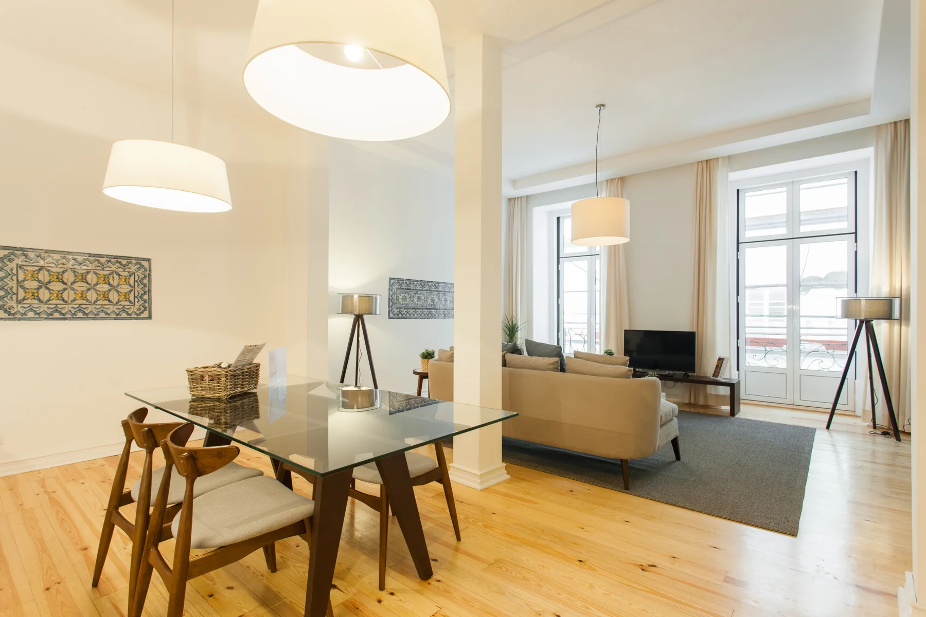 Una luminosa sala de estar y comedor con mesa, asientos y grandes ventanas.