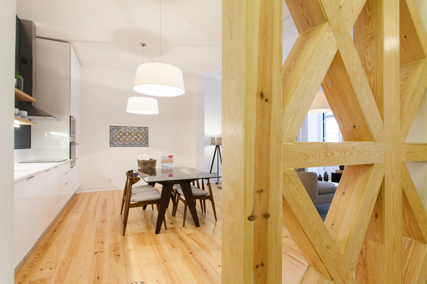 Comedor con una mesa de madera y sillas junto a una cocina luminosa.