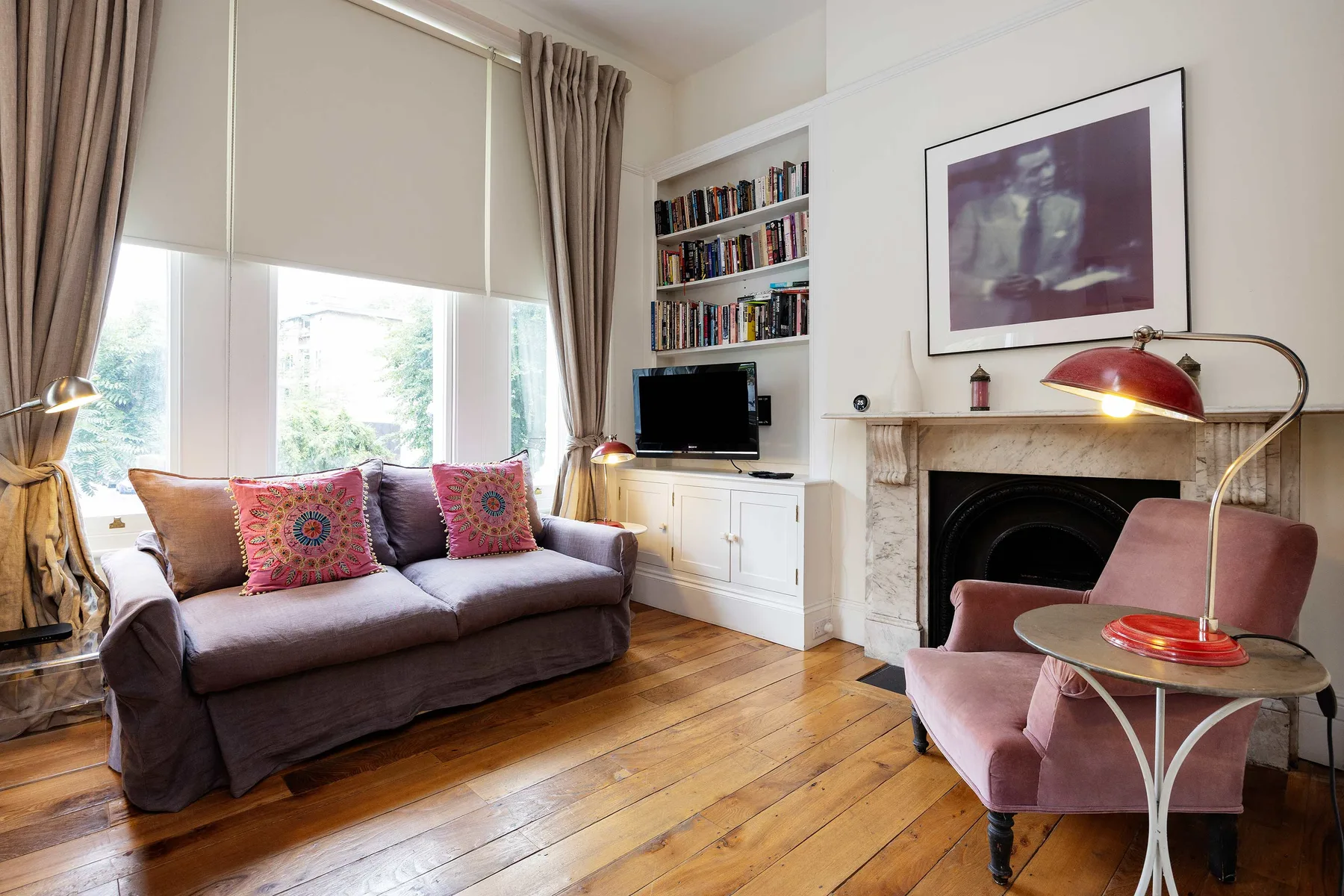 A living room with a sofa, a television, and a fireplace.