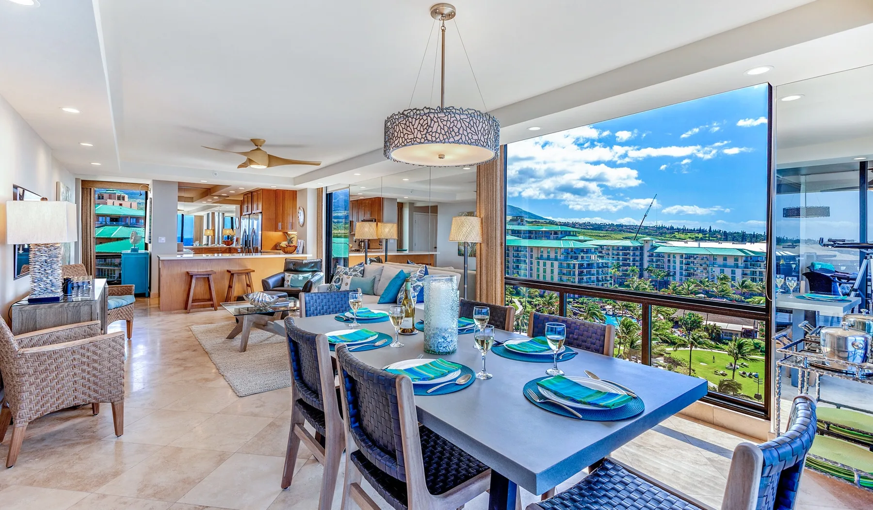 An open-plan dining and living area with a large table beside floor-to-ceiling windows.