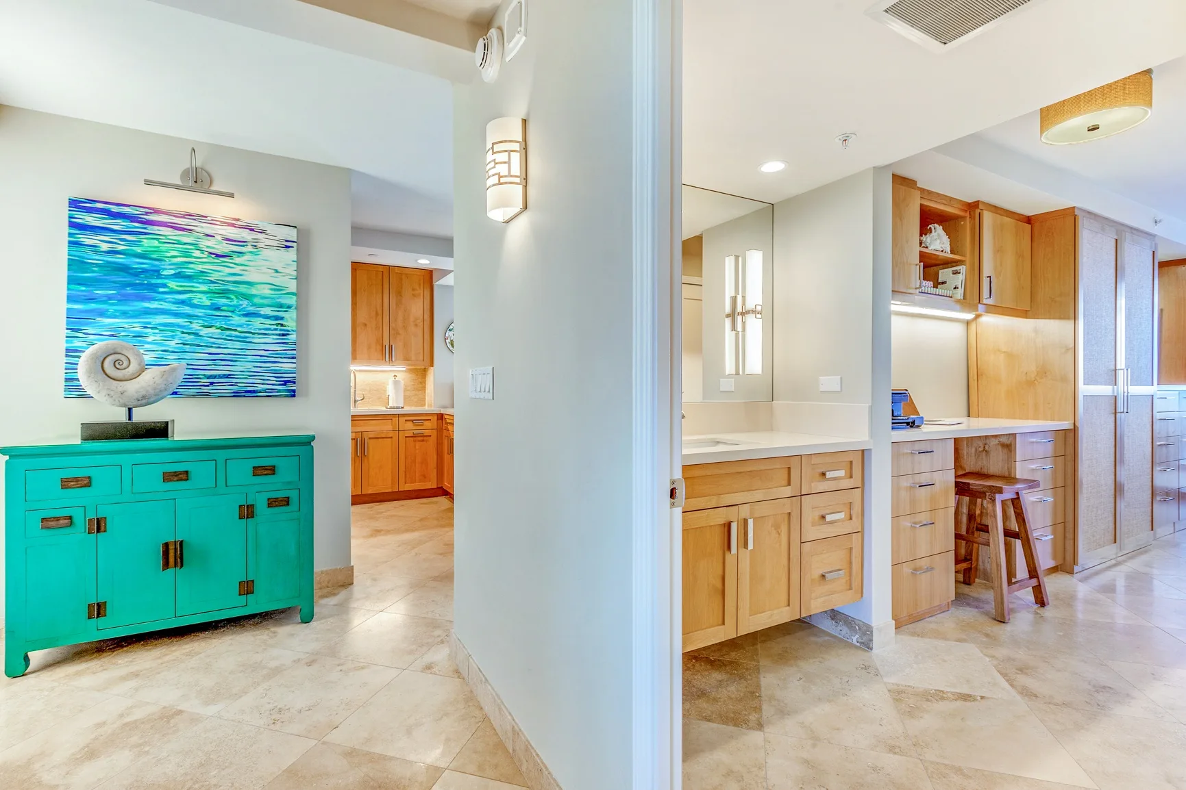 A bright kitchen and dining area with wood cabinetry and a turquoise sideboard.