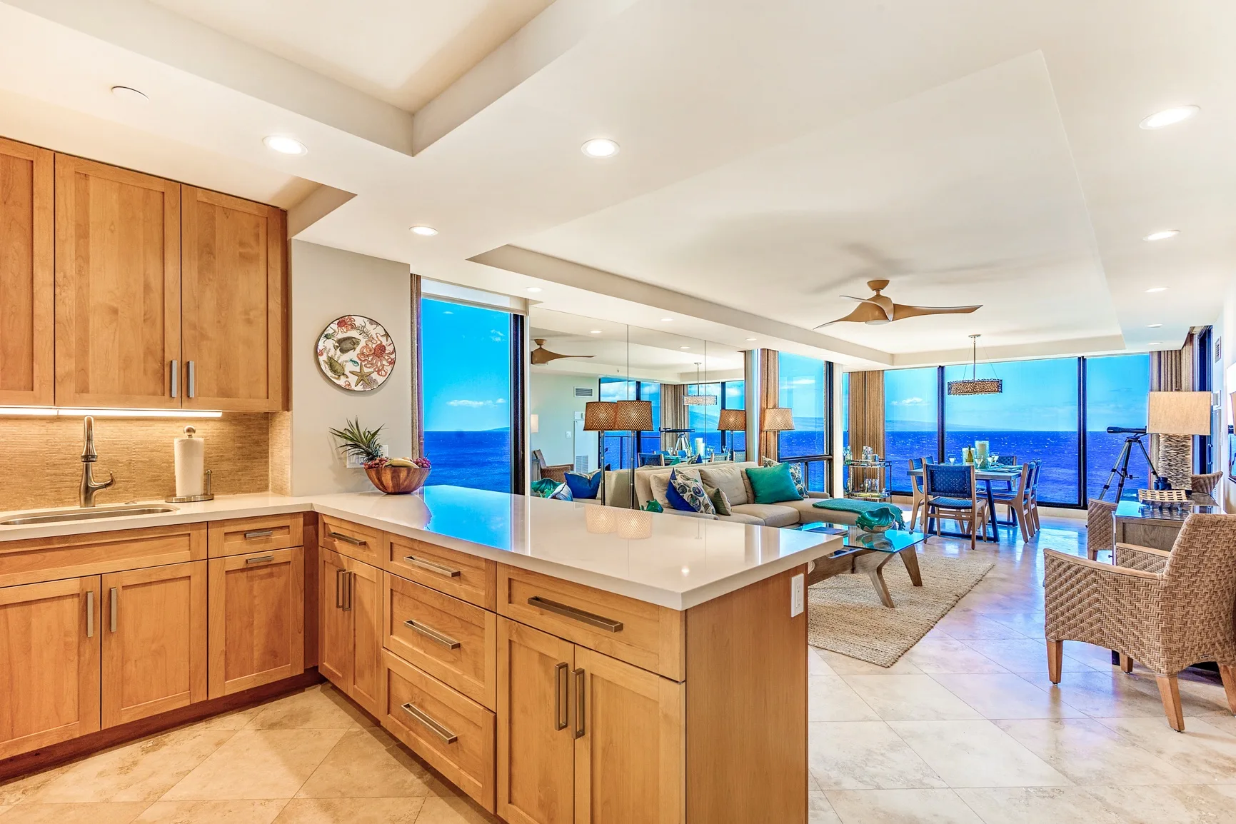 Una cocina abierta y sala de estar cuentan con una isla grande y ventanas con vista al agua.
