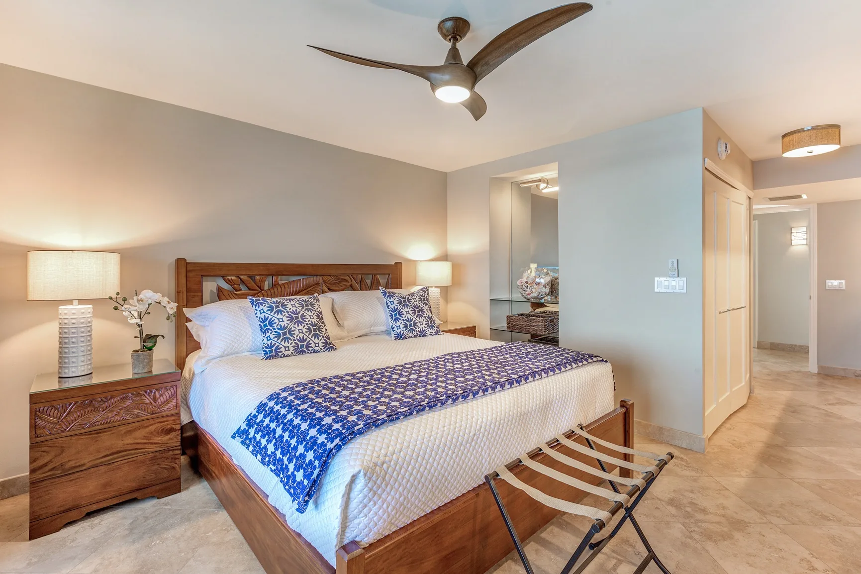 A bedroom with a bed dressed in white and blue bedding.