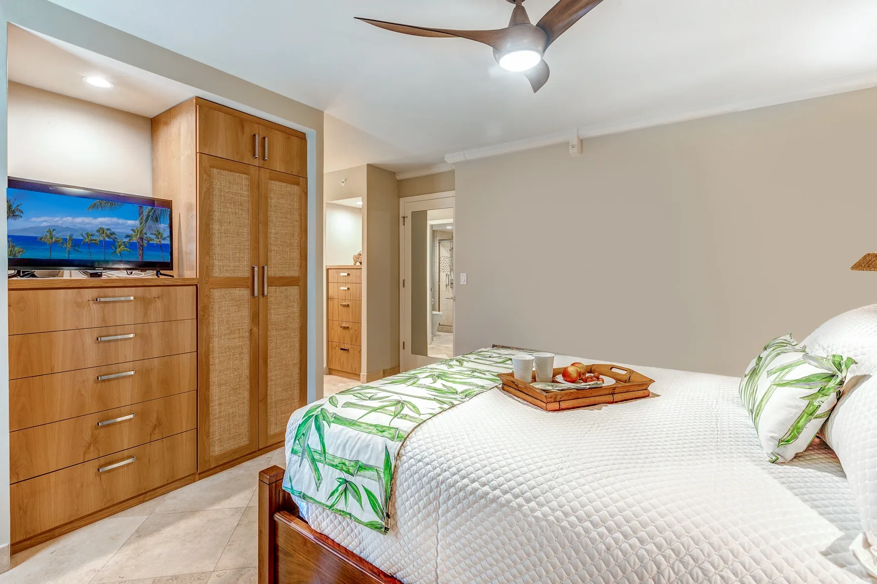 A bedroom with a neatly made bed and wooden storage furniture.