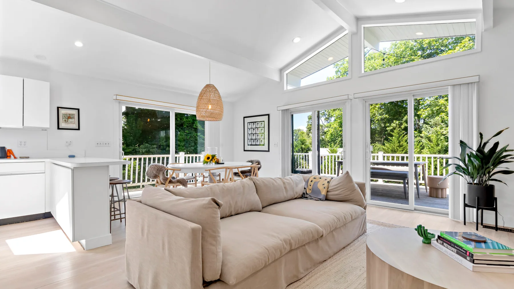 A bright open-plan living room with a large seating area beside wide glass doors.