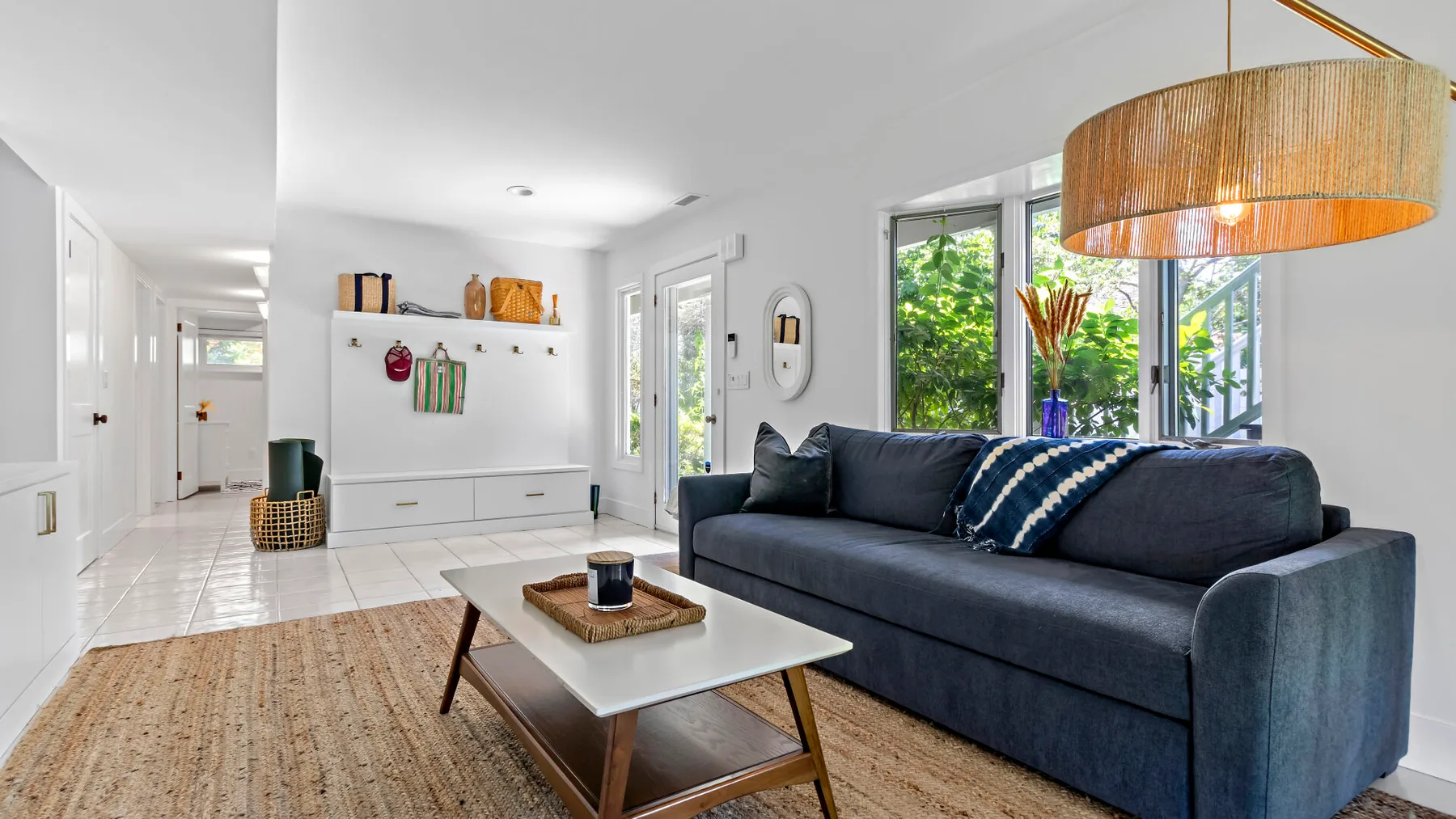 A bright living room with dark seating and a white coffee table.