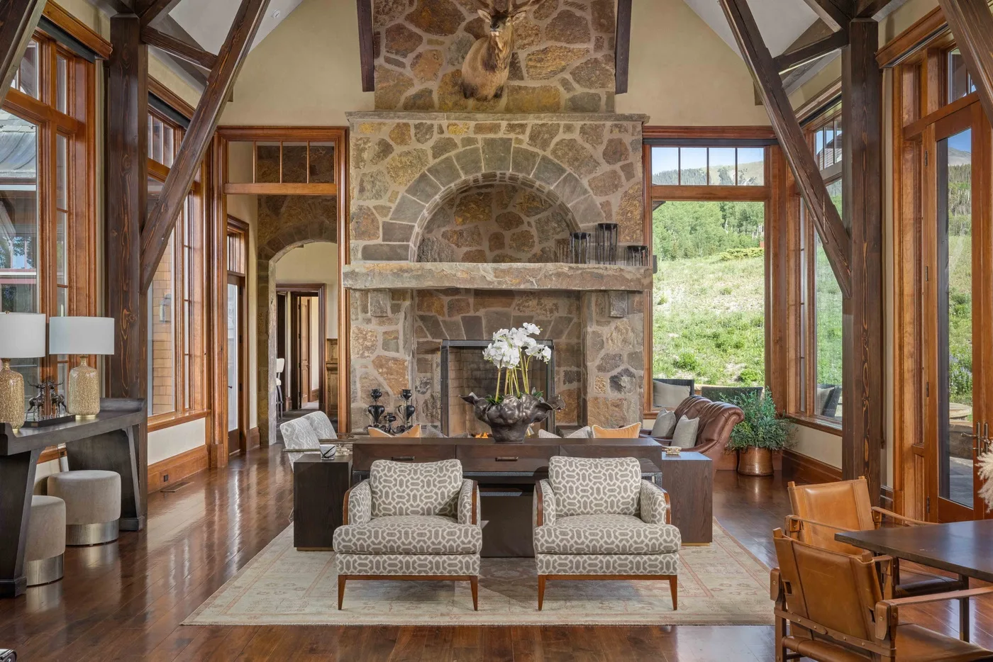 A spacious living room with a stone fireplace and seating.