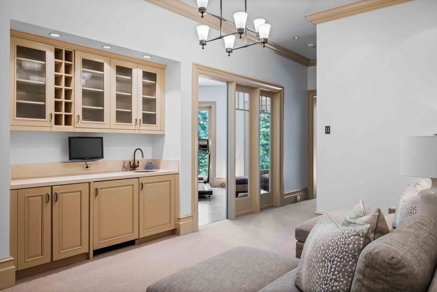 A sitting area beside a built-in cabinet and glass-paneled doors.
