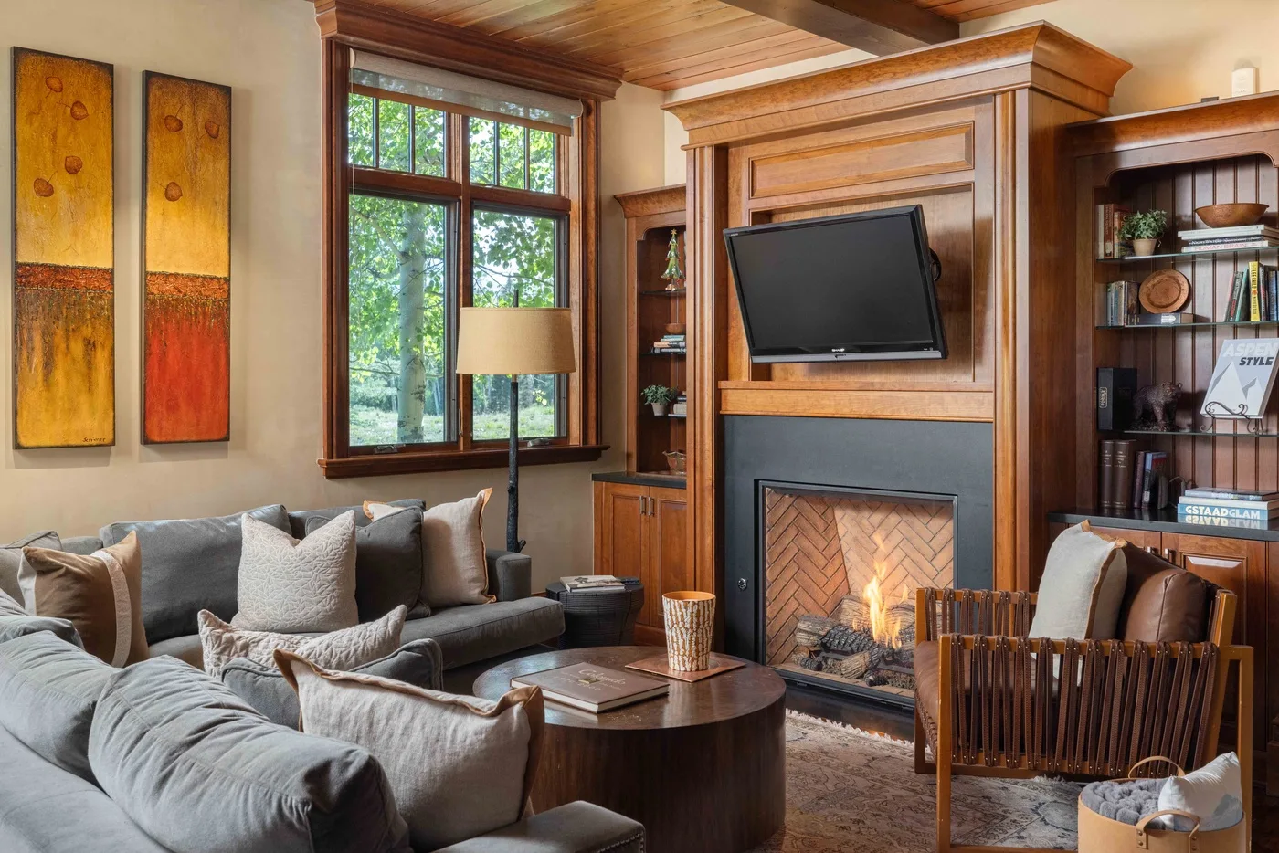 A living room with seating arranged around a coffee table and fireplace.