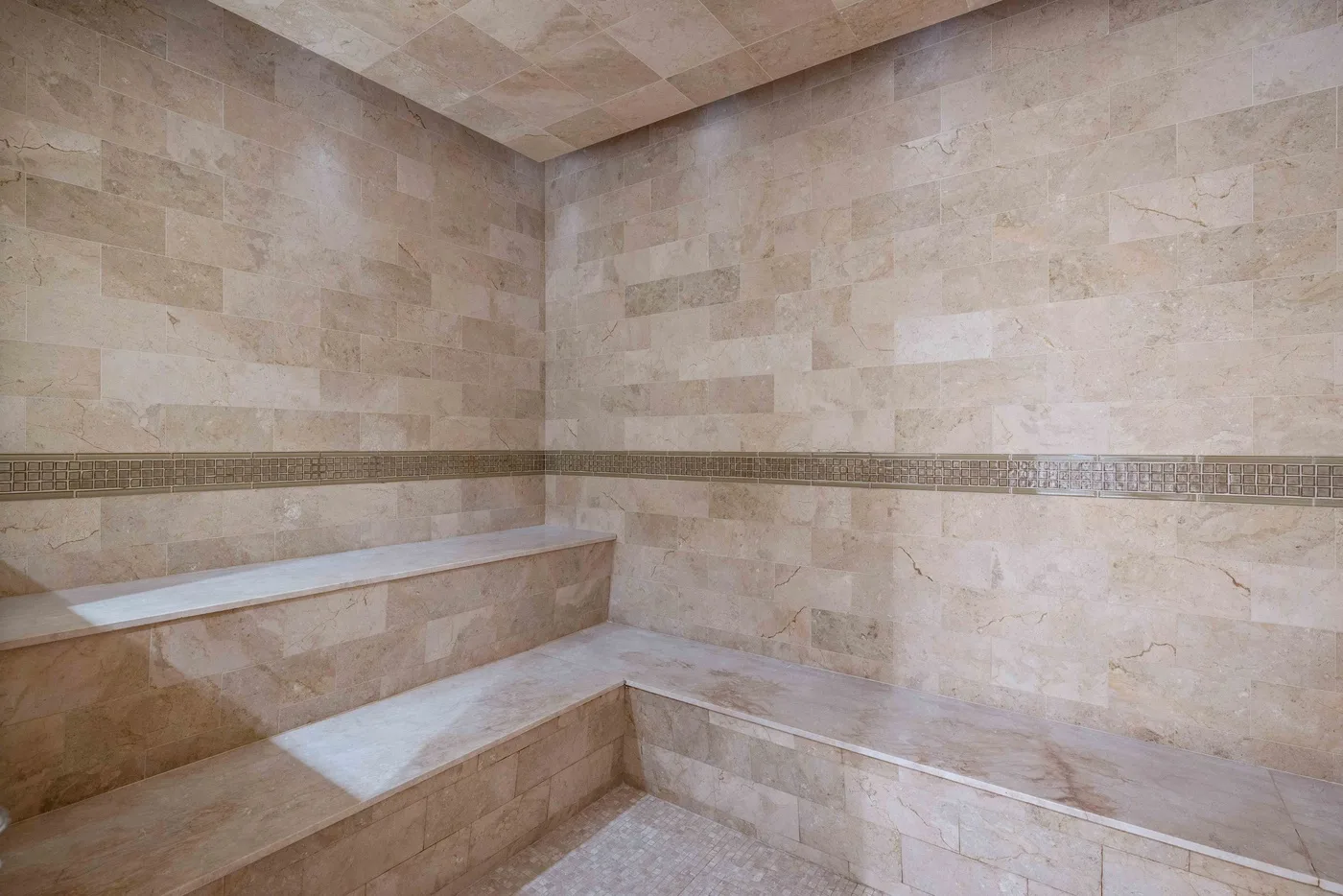 A tiled bathroom with a built-in bench along the walls.