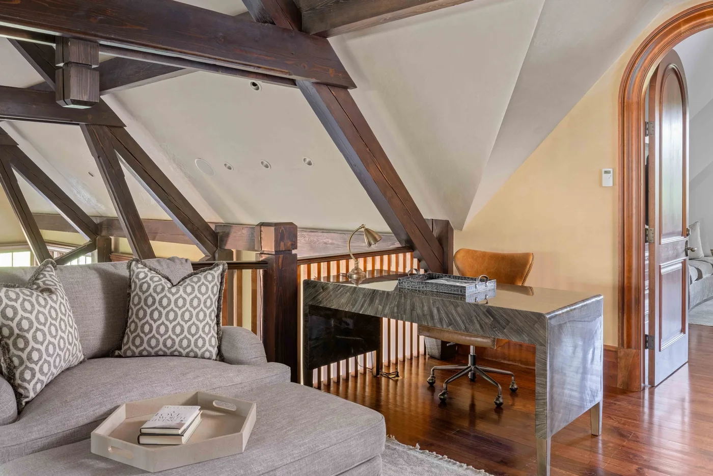 A loft-style sitting area with a desk beside the seating.