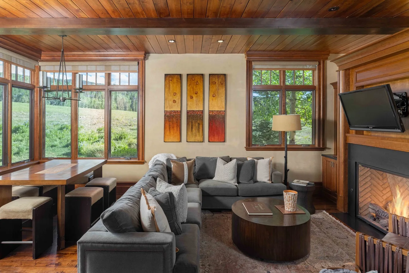 A living room with sectional seating, a coffee table, and a fireplace.