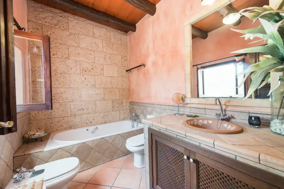 A bathroom with a bathtub and a sink beneath a large mirror.