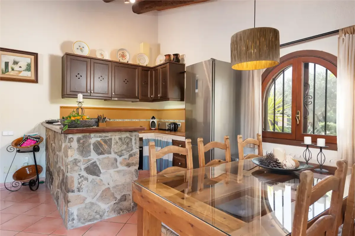 A kitchen and dining area with a stone-fronted counter and wooden table.