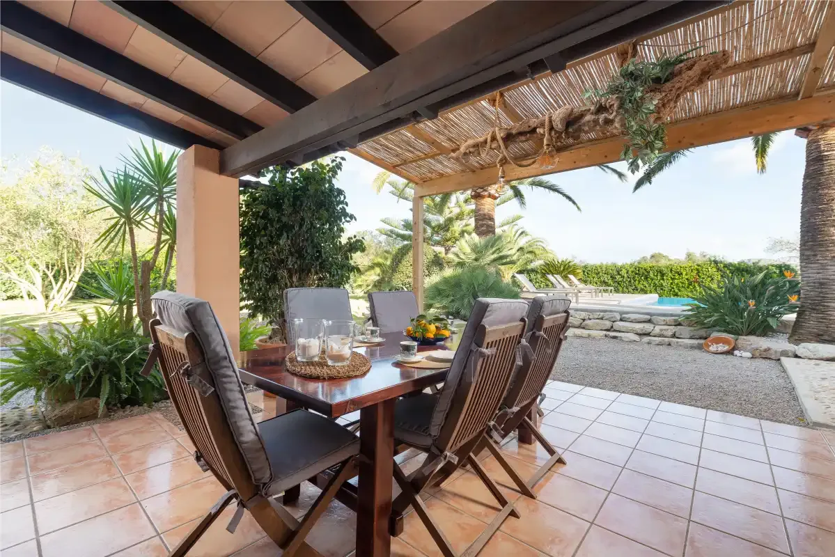 A covered outdoor dining area opens onto a garden terrace.