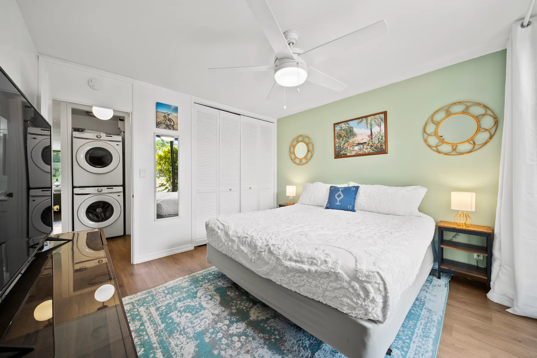 A bedroom with a bed, bedside tables, and a ceiling fan.