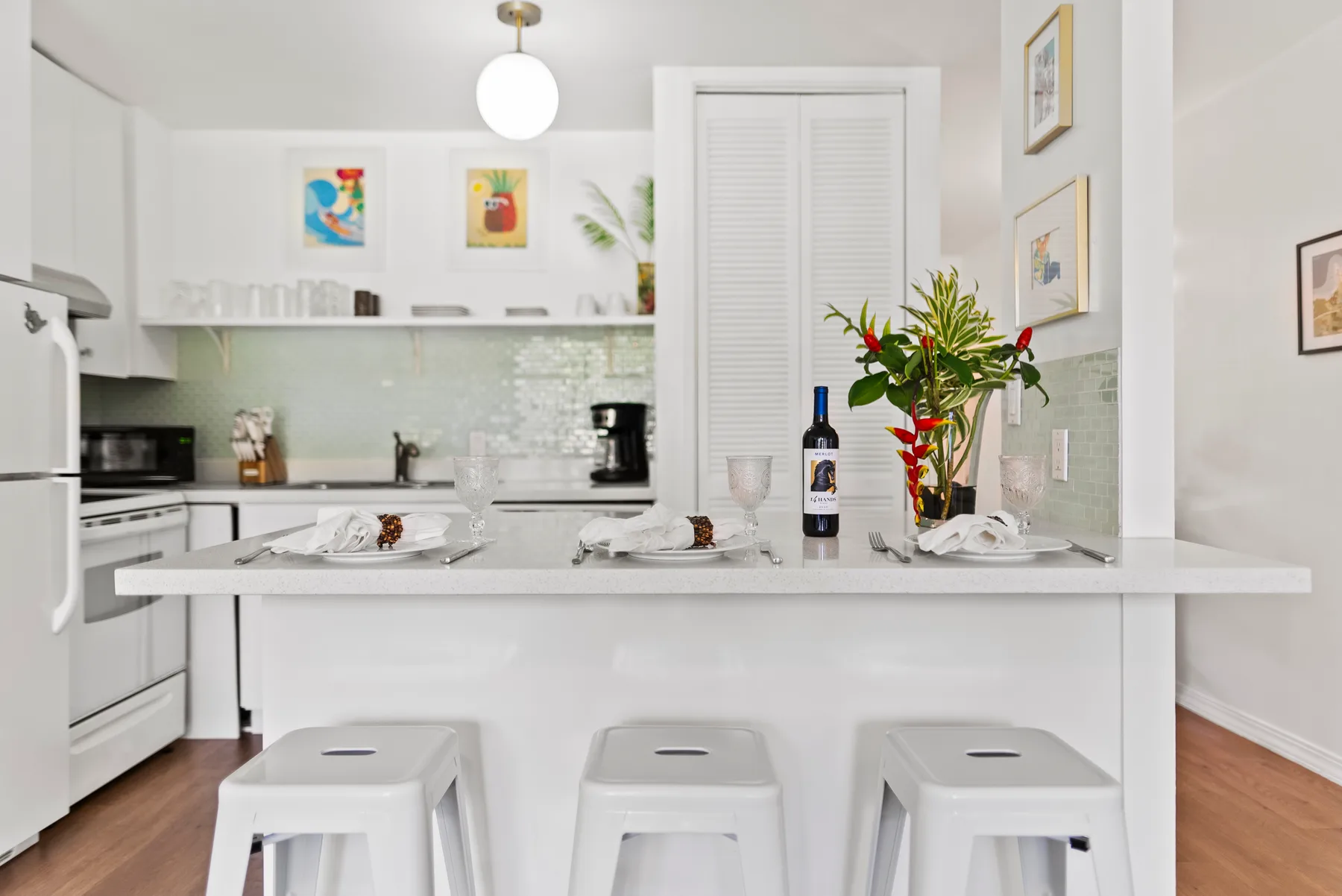 A bright kitchen with a long island and seating at the counter.