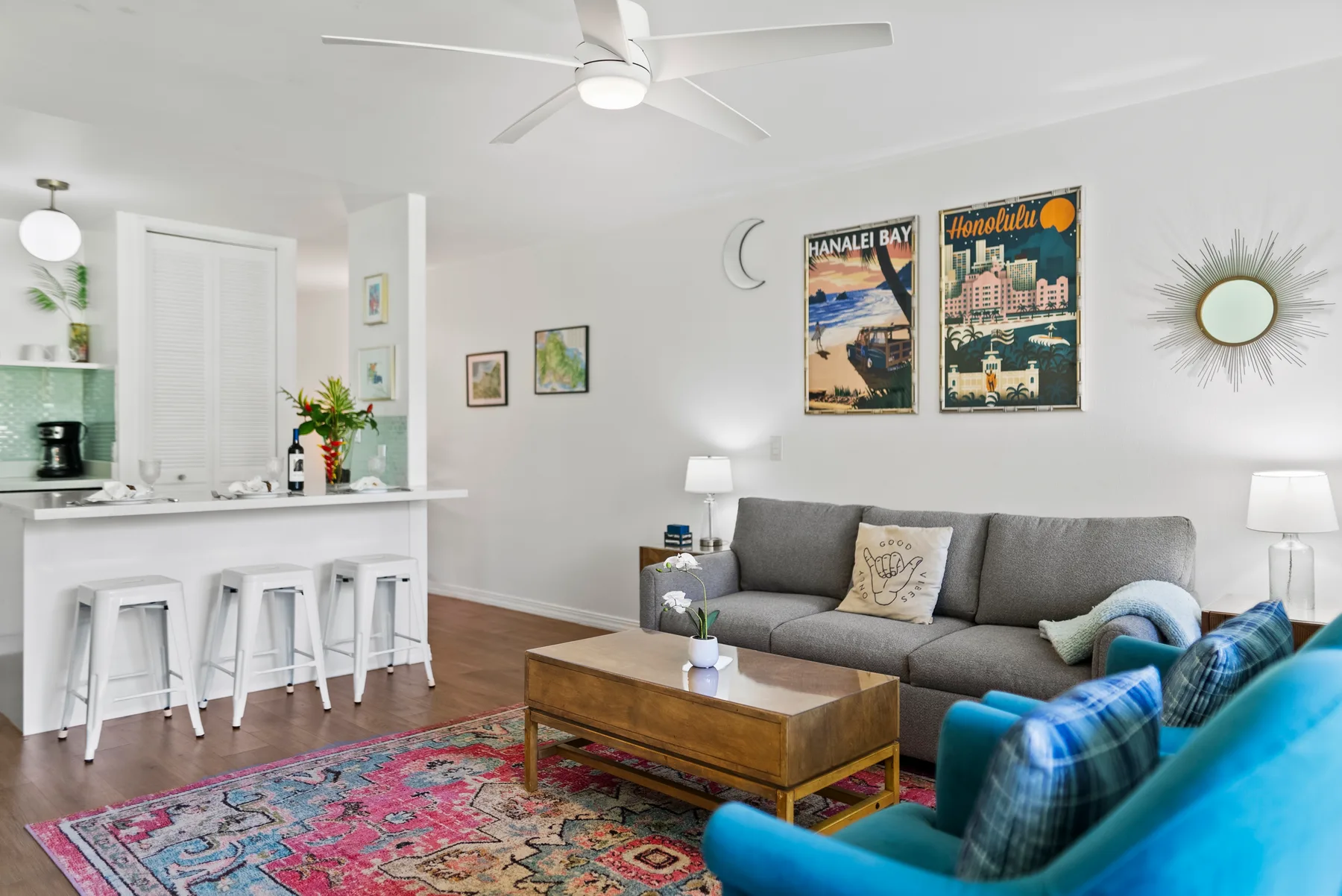 A living room with gray seating, a wooden coffee table, and colorful rugs.