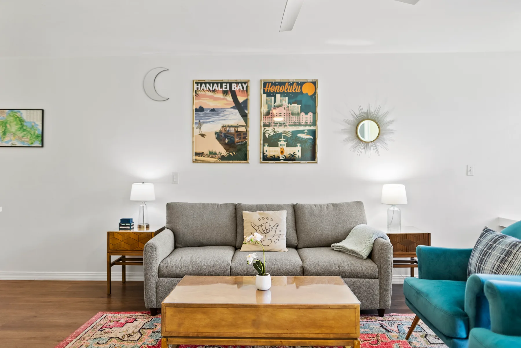 A bright living room with a gray sofa, wooden coffee table, and colorful rug.