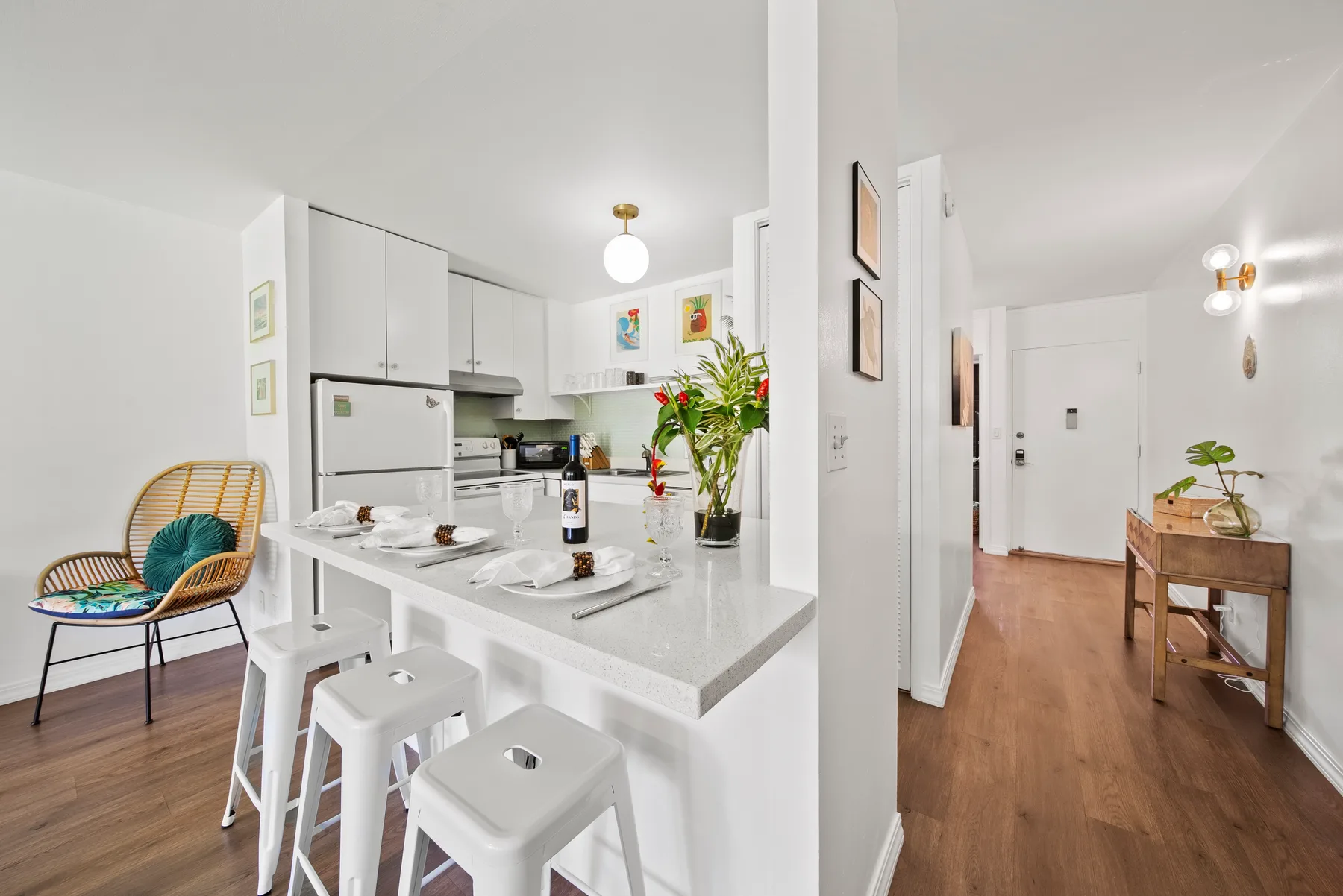 A bright open-plan kitchen and dining area opens onto a wood-floored hallway.