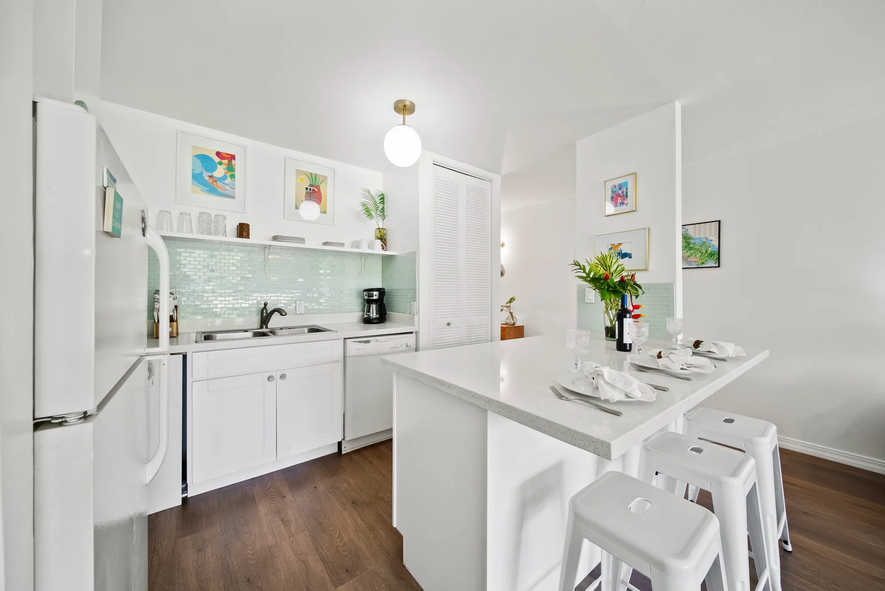 A bright kitchen and dining area with white cabinetry and a central island.
