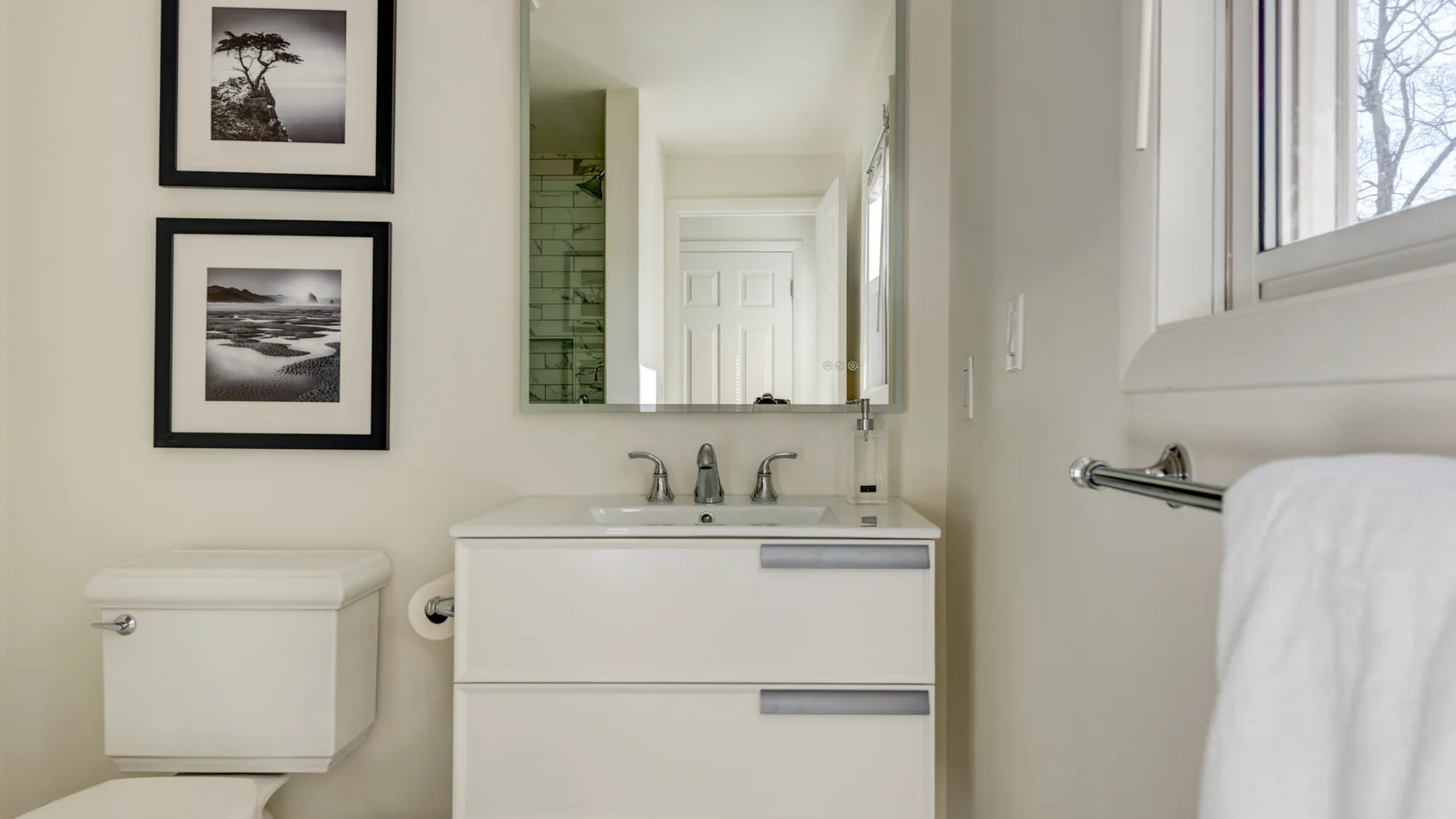 Un baño luminoso con lavabo, espejo e inodoro.