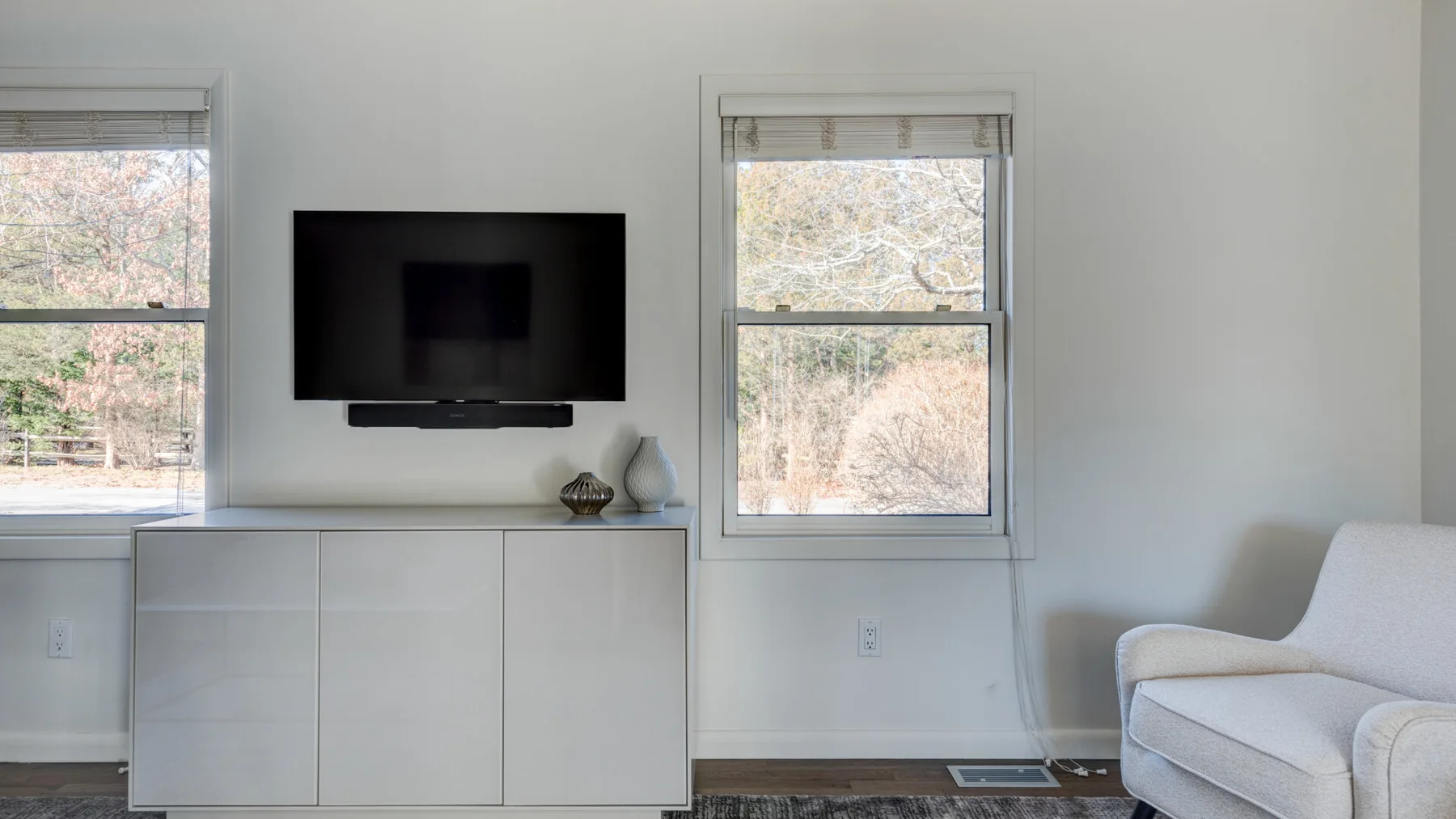 Una sala luminosa con un televisor montado en la pared y asientos.