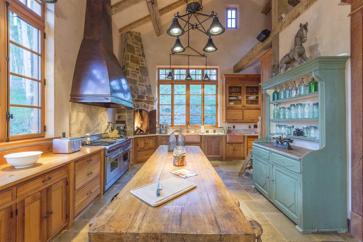 Una amplia cocina rústica con armarios de madera, una isla grande y ventanas altas.