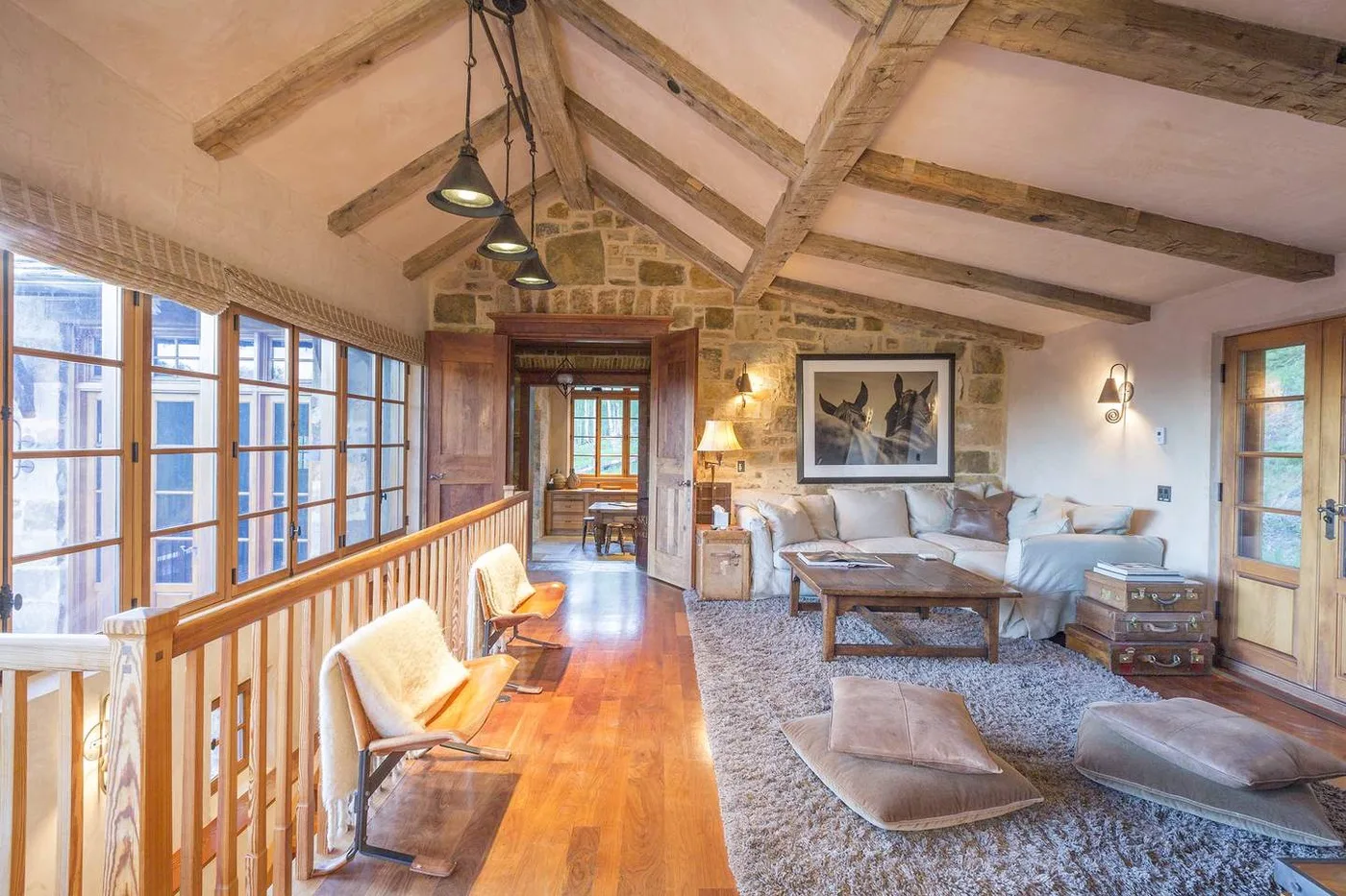 Una luminosa sala de estar con vigas de madera vistas y una zona de asientos.