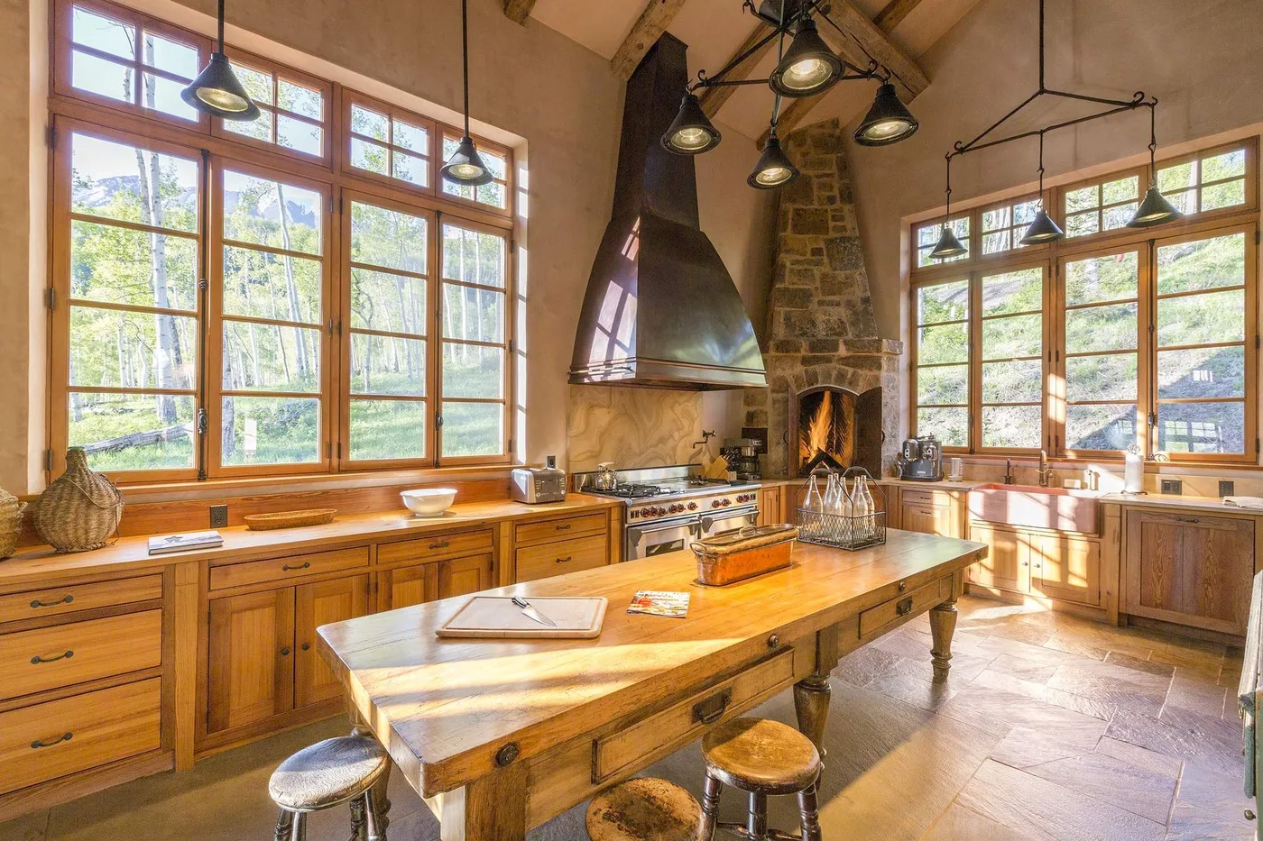 Una cocina amplia con gabinetes de madera, una isla central y ventanas grandes.