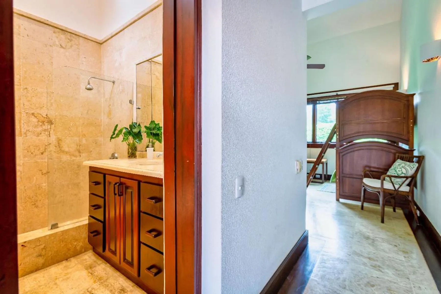Un lavabo y una ducha se abren a una habitación luminosa con asientos.